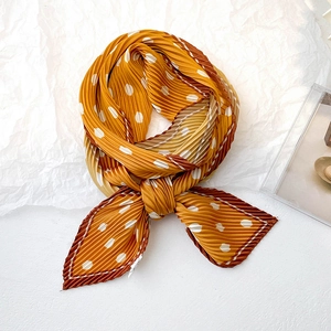 Close-up of pleated ginger yellow polka dot scarf with vintage geometric border
