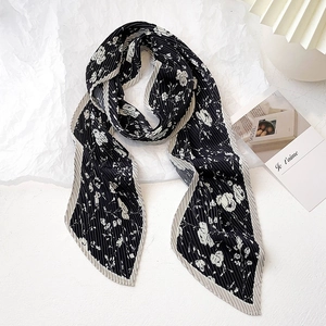 Détail d'une écharpe plissée florale avec imprimé noir et blanc et bords volantés