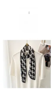 Detail of French pleated silk scarf with black and white diamond pattern on a white top