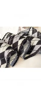 Detail showing the pleated fabric texture and delicate edge stitching of diamond pattern scarf
