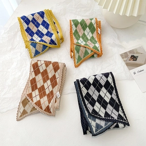 Detailed view of pleated silk scarves with classic argyle patterns in four elegant colors