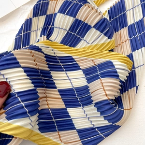 Detail of blue and yellow diamond check pleated silk scarf with accordion texture