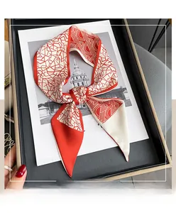 Détail d'un foulard twilly en soie géométrique rouge et blanc avec motif pied-de-poule