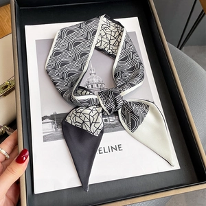 Détail d'un foulard en soie géométrique noir et blanc avec des pointes en biais sur revue