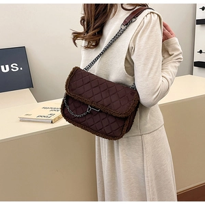 Détail du sac bandoulière matelassé marron foncé avec bordure en peau lainée et chaîne