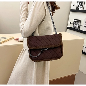Détail du sac matelassé marron foncé avec bordure peluche et chaîne argentée