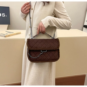 Sac bandoulière marron matelassé avec chaîne et bordure en polaire porté par un mannequin