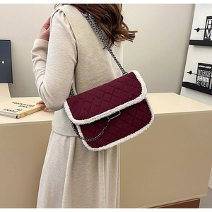 Détail du sac matelassé bordeaux avec bordure en peau lainée et chaîne argentée