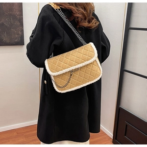 Détail du sac à chaîne matelassé jaune avec bordure en peau de mouton sur un mannequin