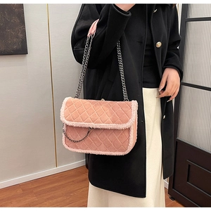Détail d'un sac en daim matelassé rose avec bordure en fausse fourrure et chaîne argentée