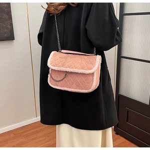 Sac à bandoulière matelassé rose avec garniture en fausse fourrure porté par mannequin