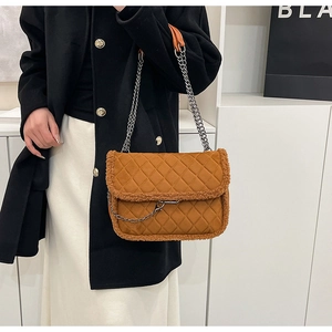 Détail du sac bandoulière matelassé marron avec bordure en laine et chaîne argentée