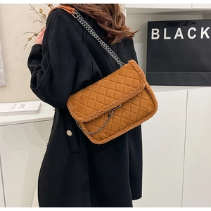 Détail du sac bandoulière matelassé marron avec bordure en peluche et chaîne