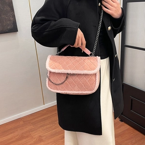 Sac à bandoulière rose matelassé avec garniture en fausse fourrure blanche porté