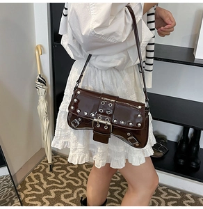 Vue détaillée du sac d'épaule en cuir verni marron foncé avec œillets rivetés argentés