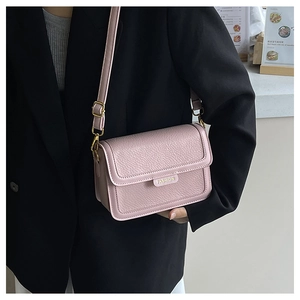 Détail du sac en cuir rose grainé avec garnitures dorées et logo FASHION