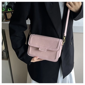 Détail du sac en cuir grainé rose avec logo mode et bandoulière réglable pour femme