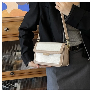 Vue macro du rabat en cuir crème beige avec boucle en métal doré et logo fashion élégant
