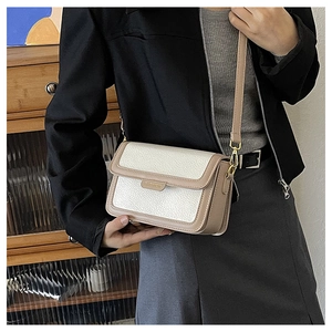 Détail d'un petit sac carré bicolore avec texture litchi et finitions métalliques