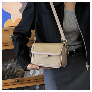 Détails de la texture du cuir grainé beige avec garnitures dorées et sceau de mode