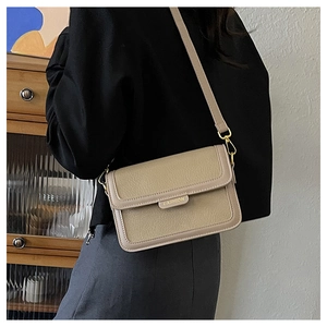 Détail du sac bandoulière en cuir grainé kaki avec boucles dorées et barre logo mode