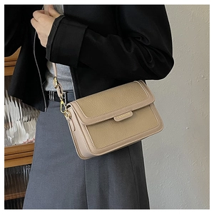 Détail du sac bandoulière en cuir kaki avec boucle dorée et finitions métalliques chic