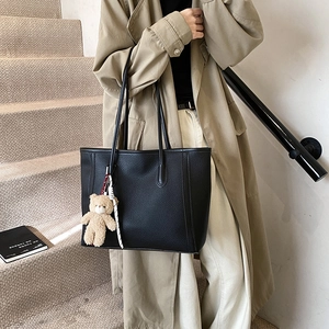 Elegante borsa tote nera a grana litchi con ciondolo a forma di orso e nastro a righe