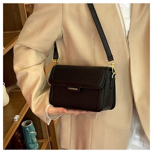 Détail du sac bandoulière en cuir noir avec boucle dorée Fashion sur le rabat