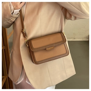 Détail d'un sac bandoulière marron en cuir avec des ferrures dorées FASHION
