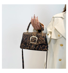 Detalle de bolso leopardo con hebilla dorada combinado con gabardina beige clásica