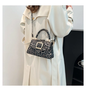 Detail of retro leopard print crossbody bag with gold metal buckle on trench coat