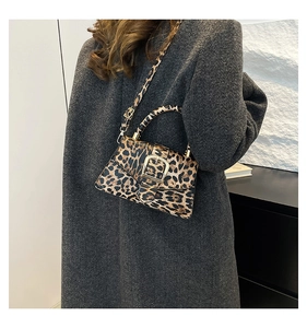 Detail of leopard print crossbody bag with gold buckle on grey wool coat