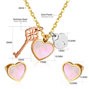 Detailed view of heart-shaped necklace and earring set with pink shell inlay and charms