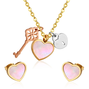 Detailed set of heart necklace and earrings with key and lock charms on white background