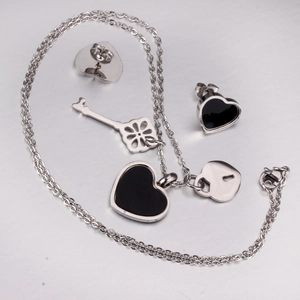 Detail of stainless steel heart necklace and earrings set with black enamel finish