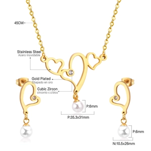 Macro detail of gold plated stainless steel heart necklace and pearl earrings set