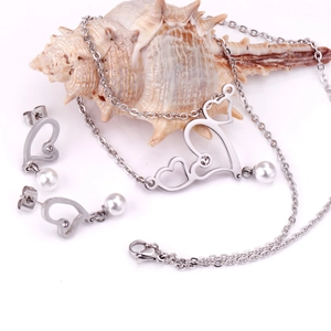 Macro shot of silver heart jewelry set featuring rhinestones and white pearl charms