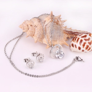 Detail of silver heart-shaped necklace and earrings set with zircons on seashells