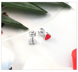 Detail of red heart earrings with secure screw back design on white textured background
