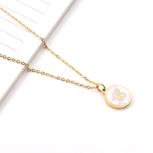 Détail macro du collier Capricorne doré avec pendentif rond en nacre blanche naturelle