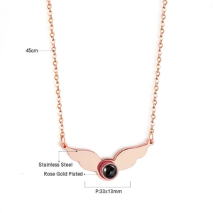 Macro detail of rose gold wing pendant with projection stone and 45cm chain