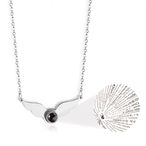 Detail of silver angel wing pendant with black stone projecting I Love You in 100 languages