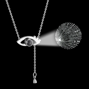 Macro shot of a silver S925 necklace with a nano-engraved projection stone showing I Love You