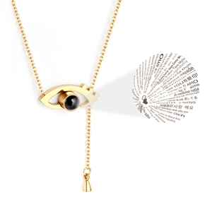 Macro detail of gold evil eye projection necklace showing 100 languages I love you