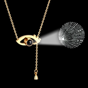 Gold devil eye heart necklace with 100 languages I love you projection on black background