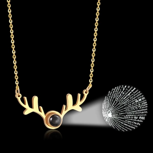 Detail of golden reindeer antler necklace showing 100 languages I Love You projection