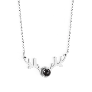 Detail of silver reindeer antler necklace featuring a central dark projection stone