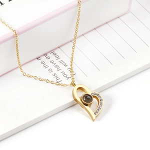 Detail of gold heart pendant with black projection stone and sparkling side stones