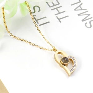 Close-up of heart projection necklace with gold plating and cubic zirconia inlay