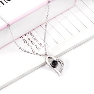 Detail shot of a silver heart pendant with projection stone and zircon accents